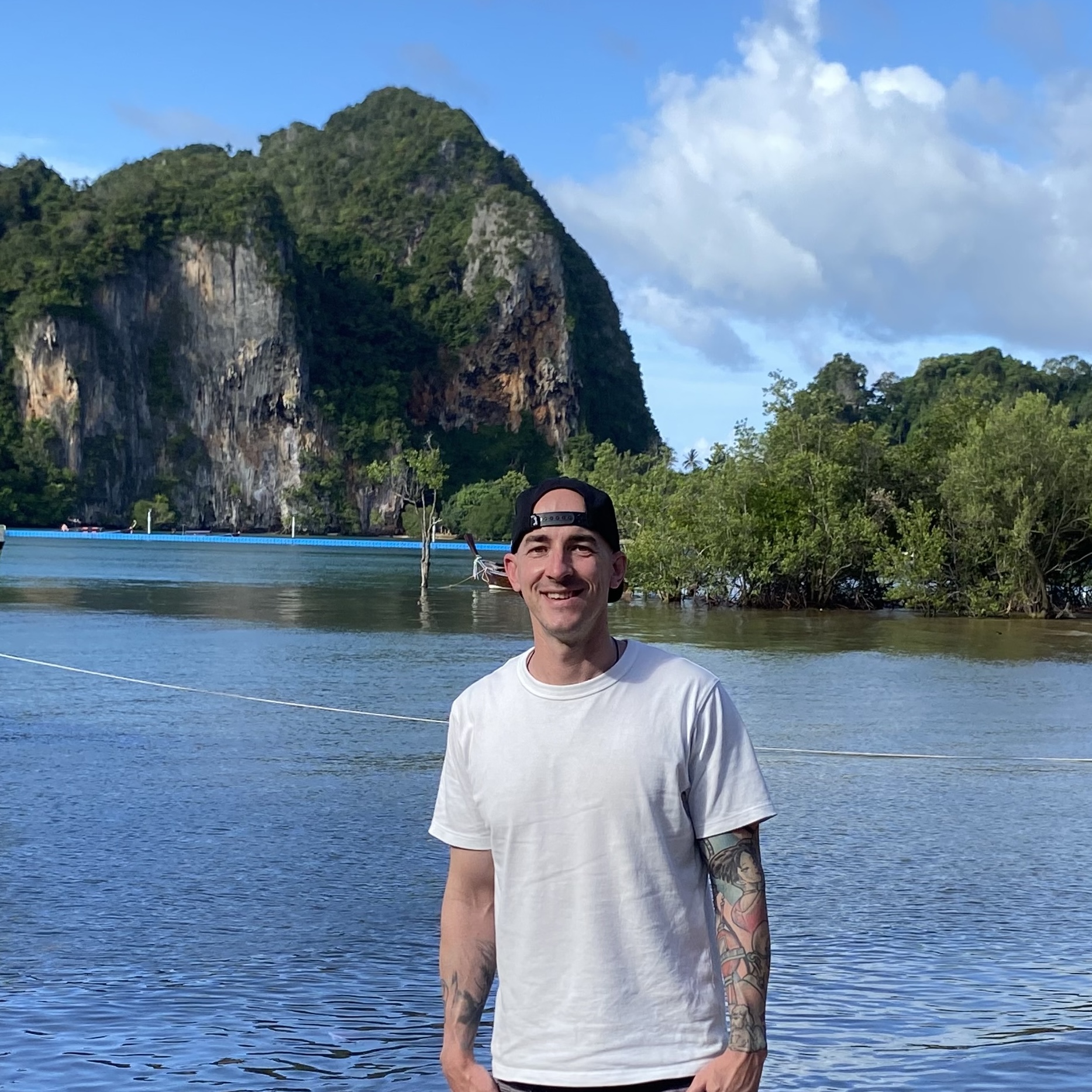 John, founder of Compass & Coast, standing by a tropical bay